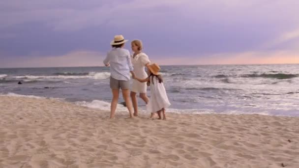 Bonitas hermanas hijas en la playa con madre sonriente. — Vídeos de Stock