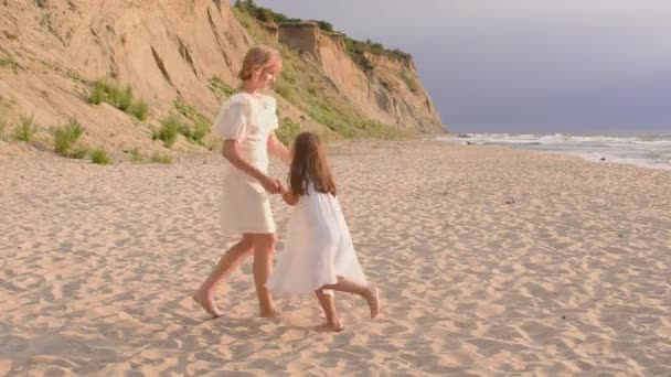 Glada unga flickor snurrar på stranden, sommar familj livsstil. — Stockvideo