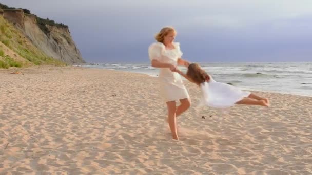 Glückliche junge Mädchen drehen sich am Strand, Sommer-Familienleben. — Stockvideo