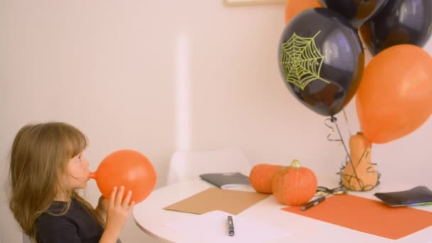 Sevimli kız Cadılar Bayramı için balonları şişiriyor. — Stok video
