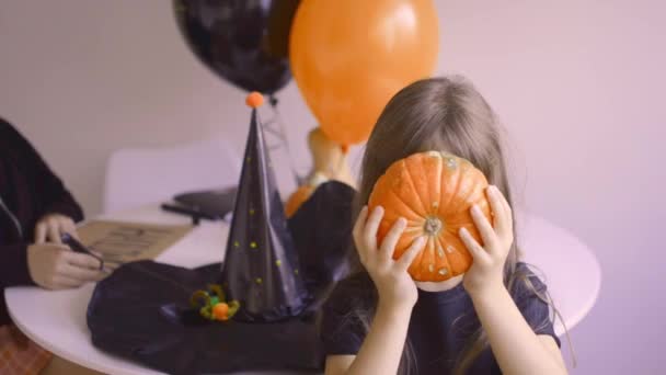 Adorable fille avec citrouille Halloween devant sa tête — Video