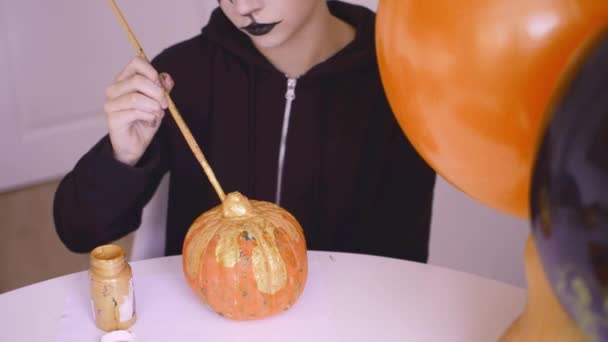 Linda chica está pintando calabazas de halloween — Vídeos de Stock
