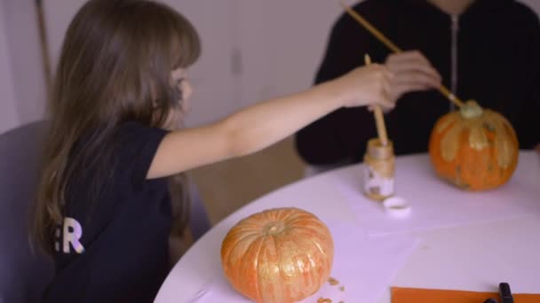 Chicas lindas están pintando calabazas de Halloween — Vídeos de Stock