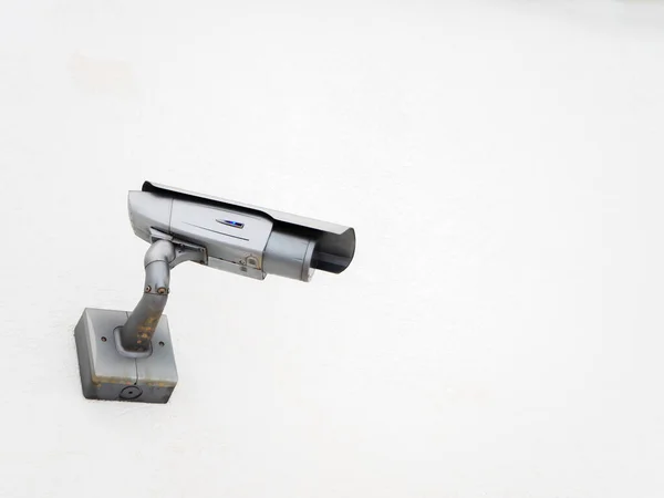 Zilveren CCTV camera schuin aan de zijkant op een witte muur — Stockfoto