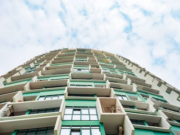 Rusia, Sochi 18.02.2020. Edificio de gran altura verde con salientes blancos sobre el fondo de un cielo nublado. Vista inferior — Foto de Stock