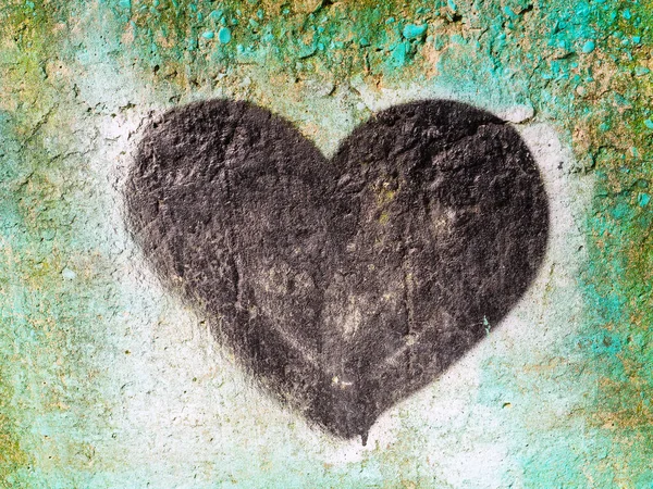 Black heart painted on a concrete wall with spray paint