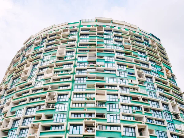 Rusia, Sochi 18.02.2020. Se trata de un moderno edificio residencial de gran altura verde construido en semicírculo. Vista inferior — Foto de Stock