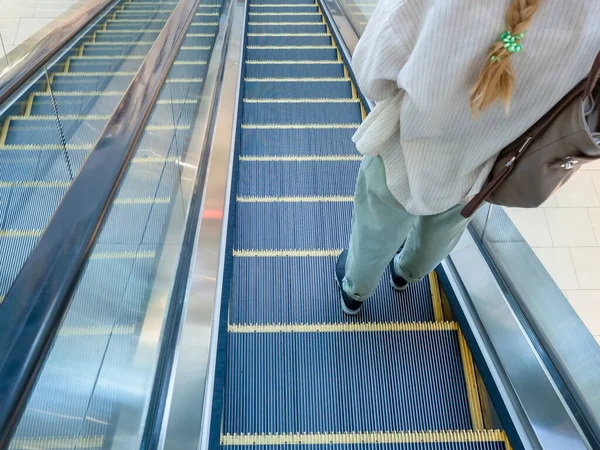 Ο Escalator κατεβαίνει με ένα κορίτσι να στέκεται πάνω του φορώντας τζιν και ένα πουκάμισο — Φωτογραφία Αρχείου