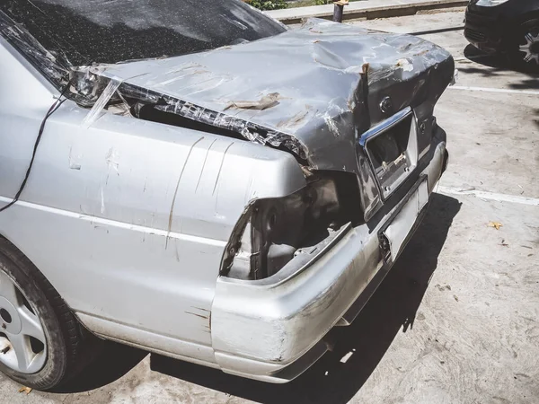 Espalda rota de un coche plateado con un maletero abollado, cinta rebobinada y faros faltantes —  Fotos de Stock