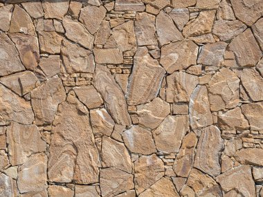 Çeşitli şekil ve boyutlarda kaba taşlardan yapılmış dekoratif bir duvar. Arkaplan dokusu
