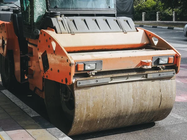 The road roller stands near the curb on the road. Road service. Closeup photo — Stock Photo, Image