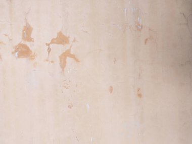 Pembe alçıda çatlaklar ve lekeler olan bir duvar. Kusursuz doku değil