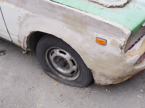 Fragmen mobil tua ditutupi dengan putty bertekstur putih dan dengan ban kempes — Stok Foto
