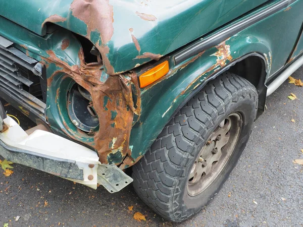 Fragmento de un coche verde con un frente oxidado roto y sin faro —  Fotos de Stock