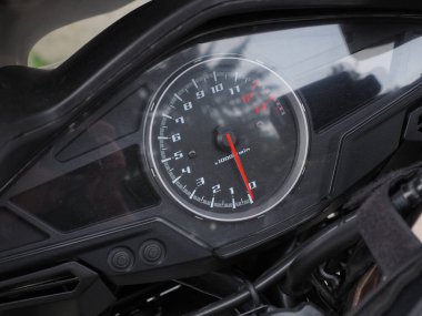 Kırmızı oklu yuvarlak bir hız göstergesi siyah bir motosikletin üzerinde yer almaktadır. Tam ekran fotoğrafı