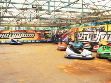 Rusya, Soçi 28.06.2020. Çok renkli arabaların olduğu boş bir otodrom duvarın karşısında üzerinde yazıtlar olan parlak bir çizimle duruyordu.