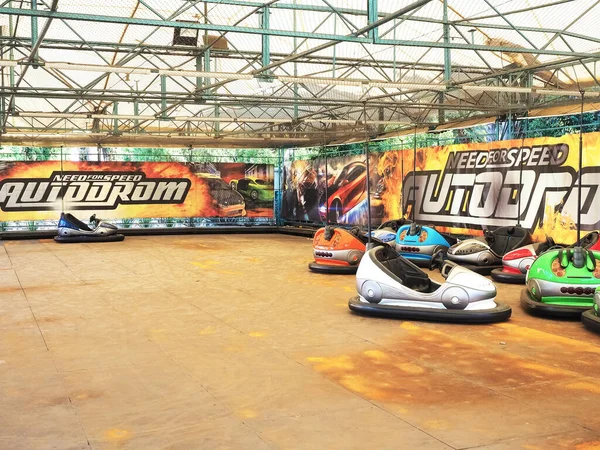 Rusya, Soçi 28.06.2020. Çok renkli arabaların olduğu boş bir otodrom duvarın karşısında üzerinde yazıtlar olan parlak bir çizimle duruyordu.