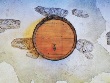 Duvarında musluk ve dekoratif alçıyla ahşap bir varil.