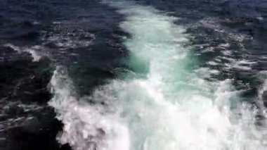 Koyu turkuaz deniz, yelkenli tekneden köpüklü bir iz.
