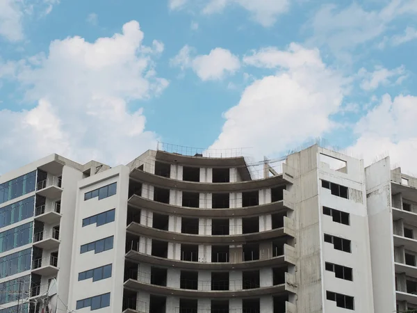 Edificio gris inacabado en estilo moderno con cielo azul y fondo de nubes — Foto de Stock