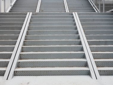 Gri, desenli üçlü demir basamaklar köprüye çıkıyor. Tam ekran fotoğrafı