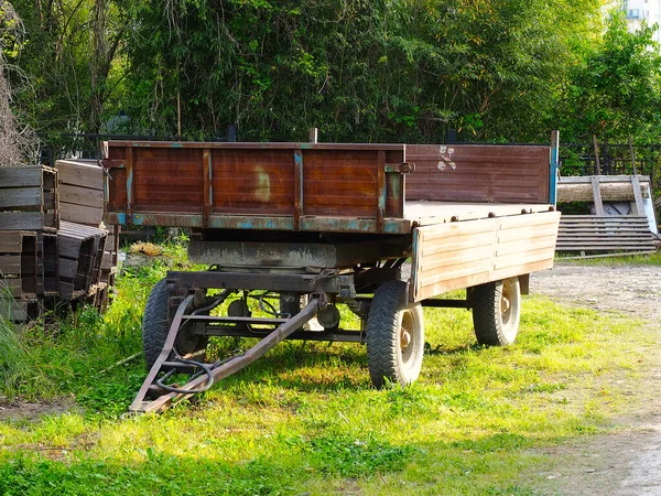 A large cargo trailer on wheels stands in the backyard on a sunny summer day — Stok fotoğraf