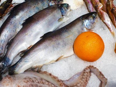 Soğutulmuş balık portakalla birlikte buzun içinde yatıyor. Balık lokantasında gösteri.