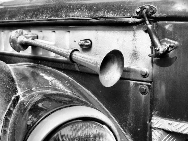 Fragment of a retro car with a signaling beep outside and splattered with dirt. Black and white photo — Stock Photo, Image