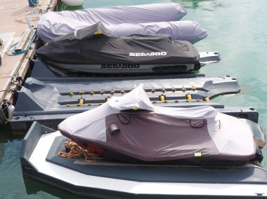 Rusya, Soçi 06.06.2021. Jetski 'ler ve tentelerle kaplı bir kaburga teknesi denizdeki rıhtıma demirlediler.