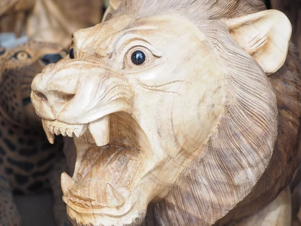 Russia, Sochi 06.06.2021. Wooden lion with open mouth. Roaring lion. Lion statuette in ethnic style. Closeup photo —  Fotos de Stock