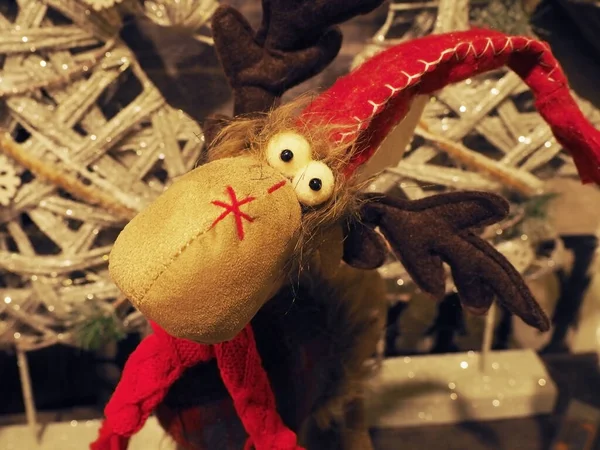 一个滑稽的柔软玩具，头戴红帽子，头戴针织围巾的弹眼鹿群。Closeup photo — 图库照片