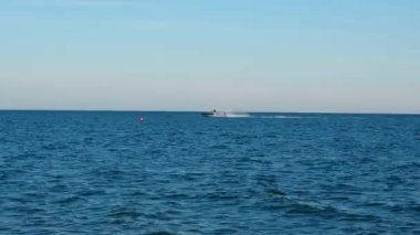 Sürat teknesi açık bir günde mavi deniz dalgalarında hızlı gider.