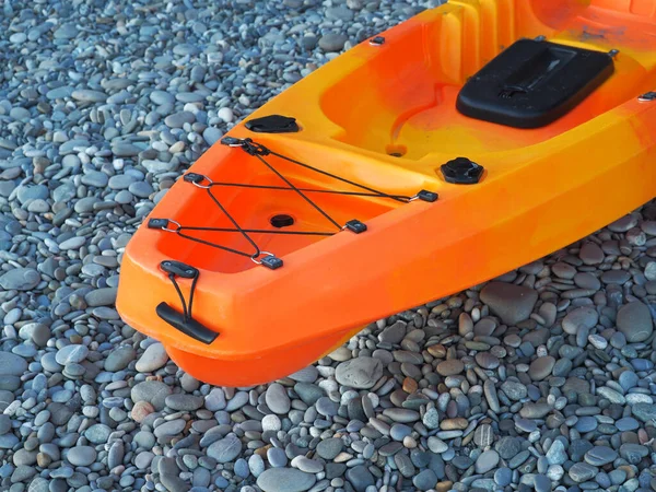 Caiaque de mar laranja único assento para a pesca na costa do calhau — Fotografia de Stock