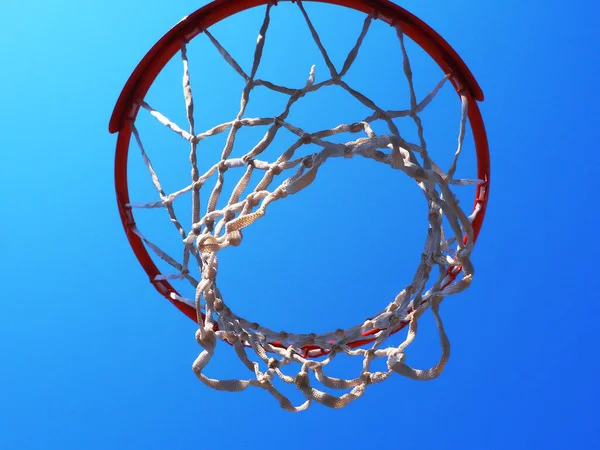 Aro de baloncesto con una red contra un cielo azul sin nubes. Foto de primer plano de abajo hacia arriba —  Fotos de Stock