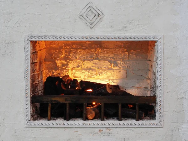 Lareira decorativa branca com lenha e fogo falso. Decoração de interiores — Fotografia de Stock