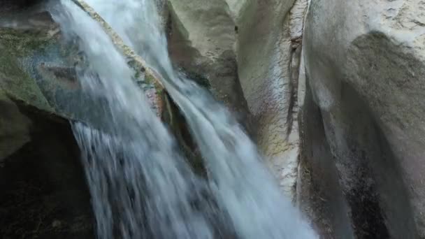 Una corriente de agua que fluye por la superficie rocosa en relieve. Una cascada que fluye sobre las rocas. Vista de cerca — Vídeos de Stock