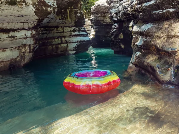 Un luminoso cerchio di nuoto galleggia nel limpido stagno turchese della gola del canyon — Foto Stock