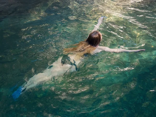 Chica de pelo largo nadando en agua clara y transparente de río turquesa. Descanse en el río —  Fotos de Stock