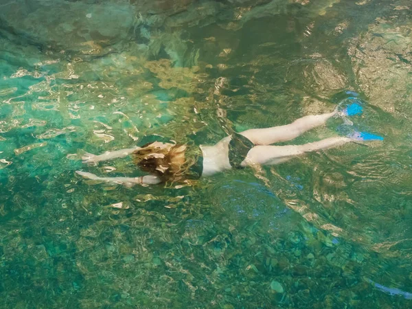 Ein Mädchen schwimmt unter Wasser in einem sauberen Gebirgsfluss mit felsigem Grund — Stockfoto