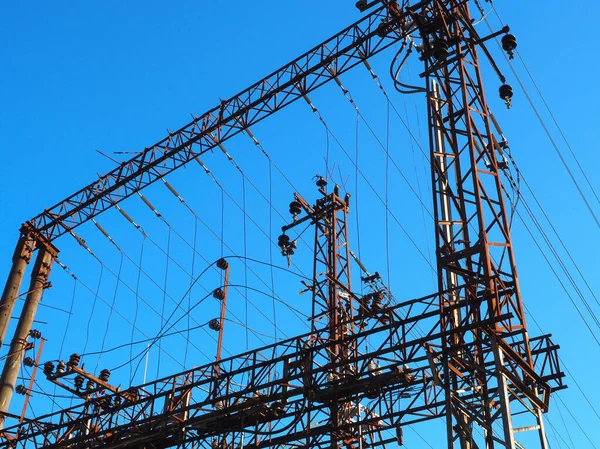 Railway electrical network with iron poles and wires on a blue clear sky background