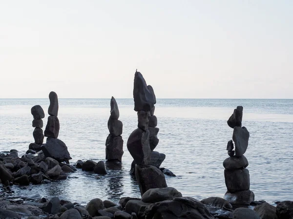 Пирамиды, построенные из больших камней, стоят на фоне спокойного моря — стоковое фото