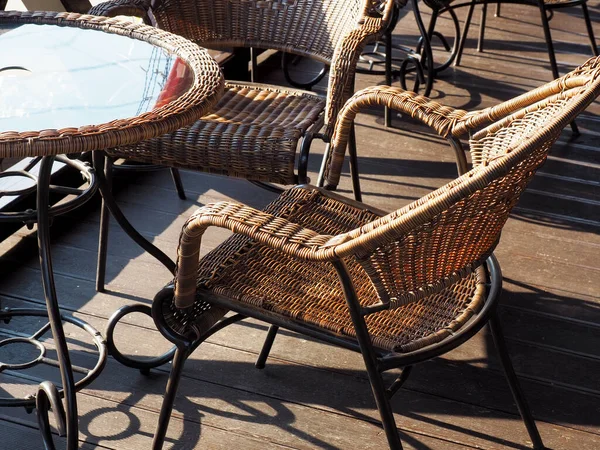 햇볕 이 잘 드는 위켓 의자는 나무 베란다 위 탁자에 놓여 있다. 거리 카페 — 스톡 사진