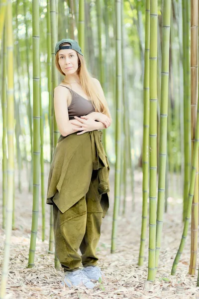 Hip-hop menina fica com braços dobrados em um bosque de bambu verde — Fotografia de Stock