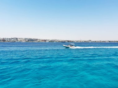 Şehir manzarası yakınlarındaki canlı mavi okyanusta sürat teknesi
