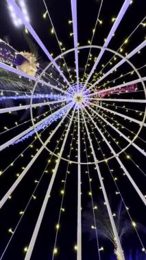 Geceleri parlayan sicim ışıkları olan dairesel yapı.