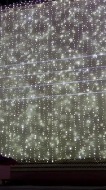 Dış duvarda asılı tel lambalarla dekore edilmiş..