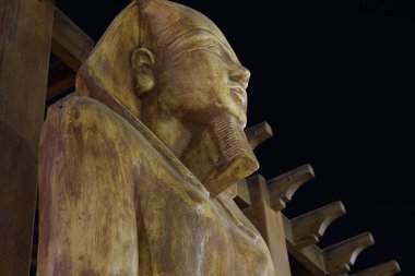 3 Eylül 2023 'te Mısır' ın Hurghada şehrinde karanlık gökyüzüne karşı yapılan Altın Firavun heykeli..