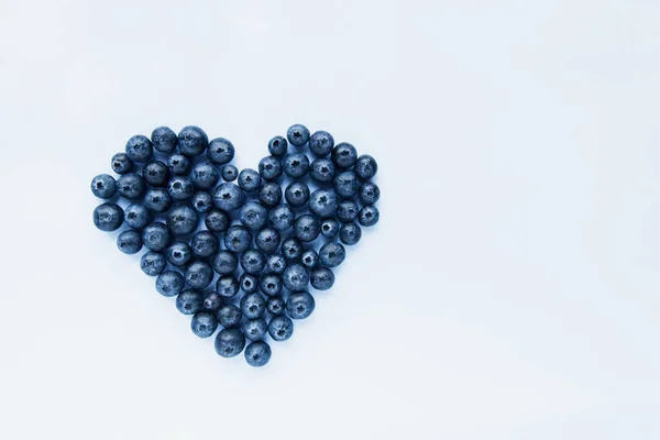 Superfood arándanos formados en forma de corazón. Comida saludable, bayas de verano. Concepto de comida mínima. Flatlay. Enfoque selectivo. Copiar espacio. — Foto de Stock