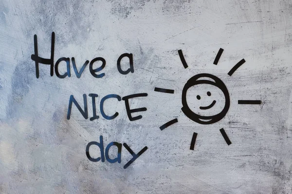 На бетонной стене красовалась красивая надпись дня и улыбающееся солнце. Позитивная концепция мышления. Селективный фокус. — стоковое фото