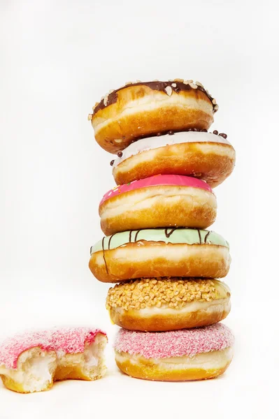 Torre de Donuts coloridos sortidos em um fundo branco — Fotografia de Stock